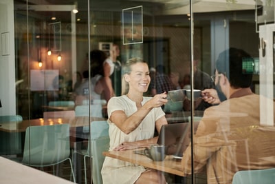 女人在白衬衫坐在咖啡店棕色夹克的男子
